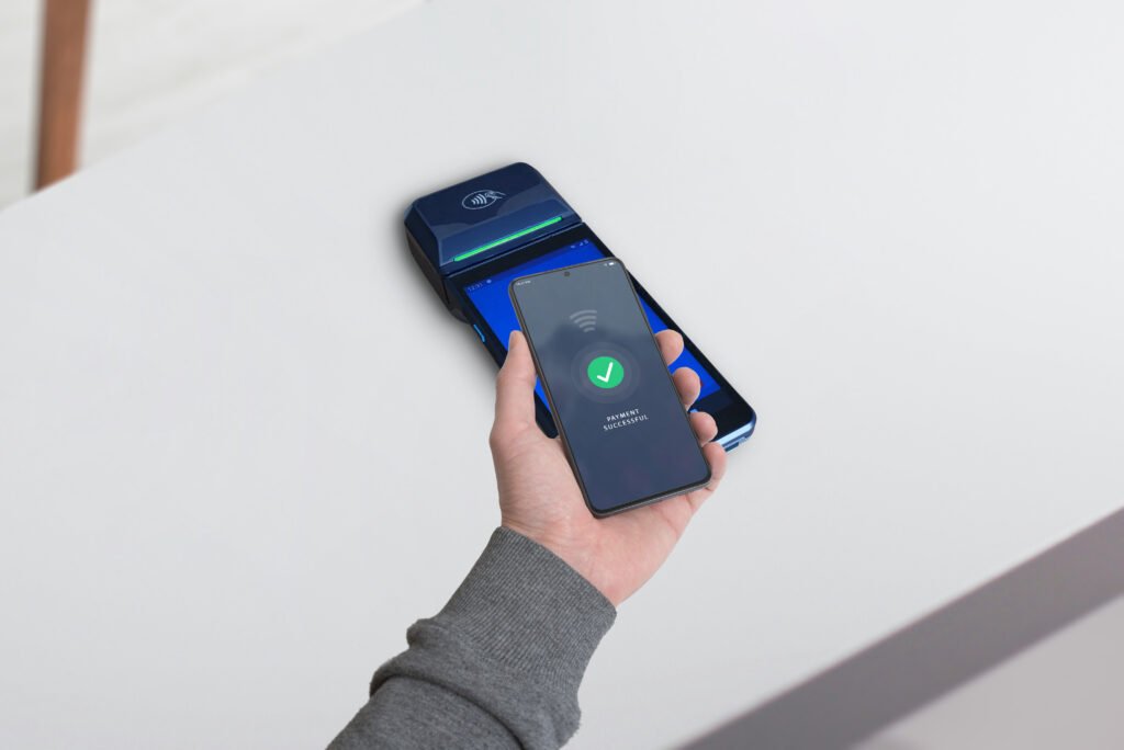Smartphone completing a payment on a POS terminal with a wireless symbol and a "Payment Successful" message displayed. Seamless mobile transaction concept