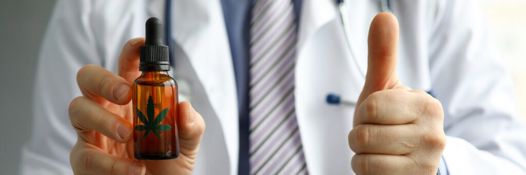 Male GP holding in hand cbd oil jar showing thumb up sign