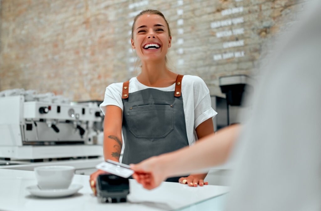 Young attractive female barista stands at the counter in a coffe