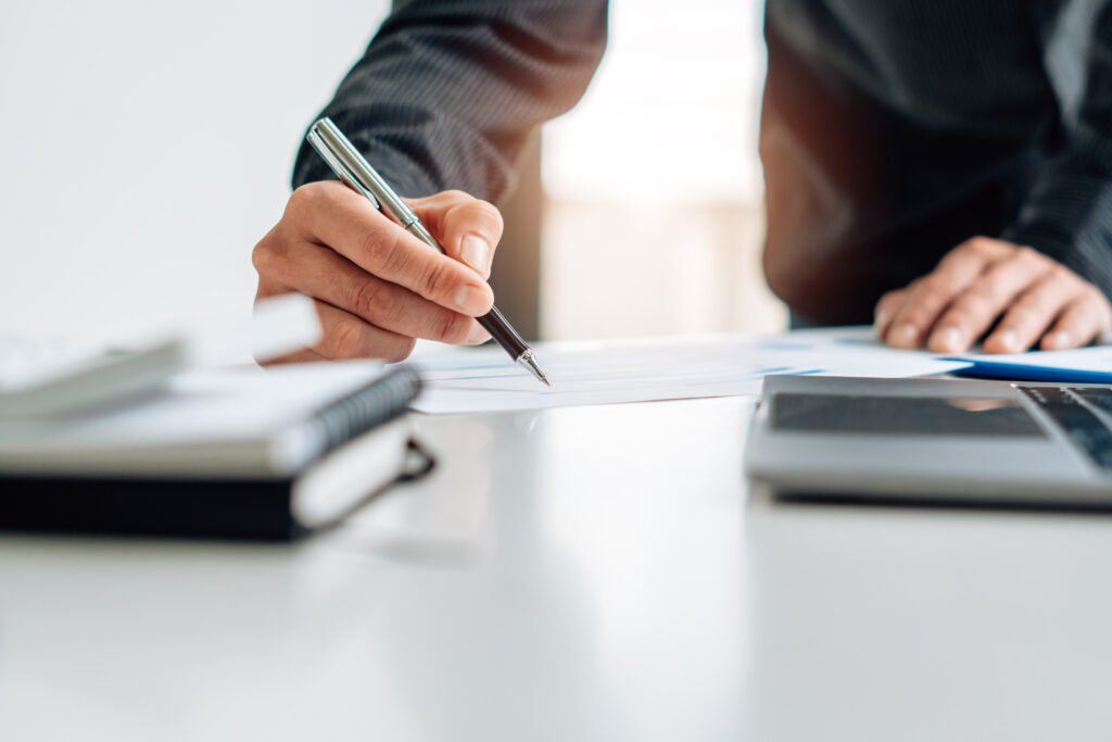 Close up view of bookkeeper or financial inspector hands making report, calculating or checking balance. Home finances, investment, economy, saving money or insurance concept.