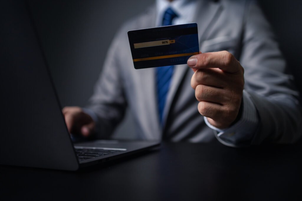 Man in suit with credit card, businessman hold credit card, using credit card to pay for goods and services in store, online shopping on website and paying by credit card. Online shopping concept.